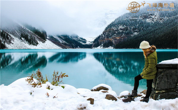 一个人站在湖边的雪地里